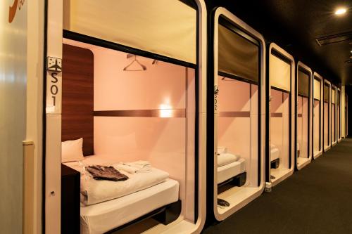 eine Reihe von Etagenbetten in einem Zimmer in der Unterkunft First Cabin Haneda Terminal 1 in Tokio