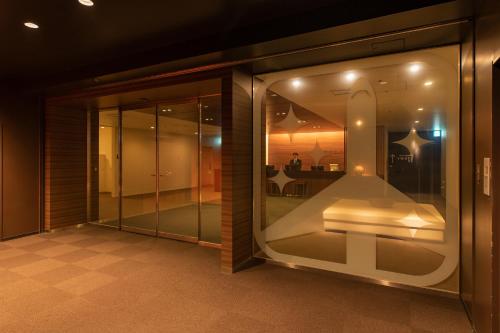 Cette chambre dispose d'une fenêtre offrant une vue sur une maison. dans l'établissement First Cabin Haneda Terminal 1, à Tokyo