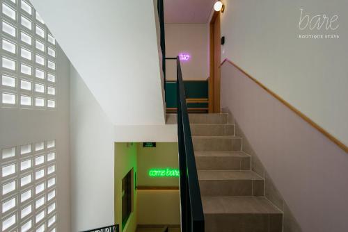 a stairway in a building with a green exit sign at Bare Han - Bare Boutique Stays in Da Nang