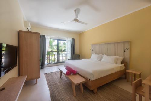 1 dormitorio con 1 cama grande y TV en Residence Praslinoise en Grand'Anse Praslin