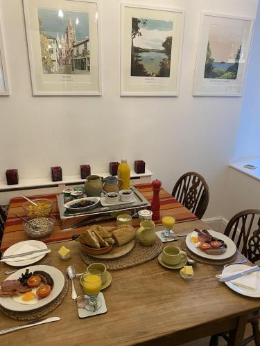 a wooden table with plates of food on it at Devonshire Terrace B&B in Truro