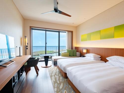 um quarto de hotel com duas camas e uma grande janela em Hyatt Regency Seragaki Island Okinawa em Onna