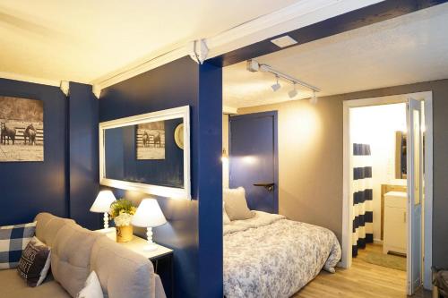 1 dormitorio con paredes azules, 1 cama y 1 silla en Nicura Ranch Inn & Stables en Berea