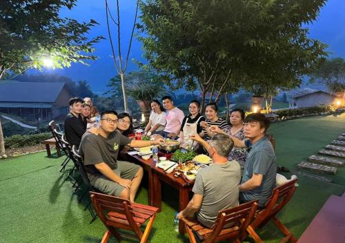 a group of people sitting around a table eating food at Sapa Eco Hugo in Sa Pa