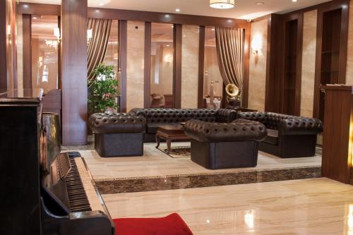 a living room with a couch and a piano at Gorukle Oruc Hotel & Spa in Bursa