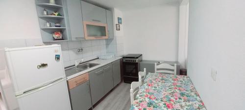a small kitchen with a table and a refrigerator at Apartments Ćemo in Sarajevo