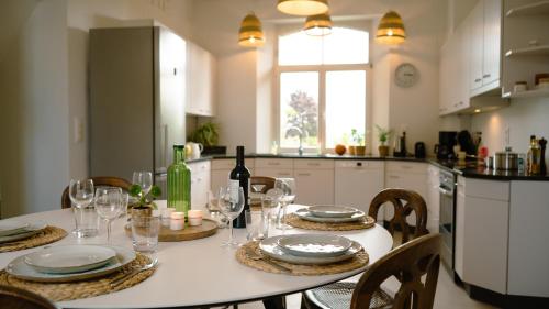 una mesa con platos y copas de vino en la cocina en Les 3 Bilobas en Héron