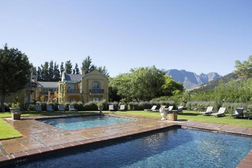 une maison avec une piscine dans la cour dans l'établissement Franschhoek Country House & Villas, à Franschhoek