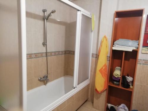 a bathroom with a shower and a bath tub with a surfboard at Piso el castillo in Medina de Pomar