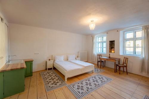 a bedroom with a bed and a desk and a table at Casa La Strada in Sighişoara
