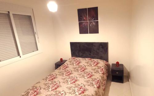 Un dormitorio con una cama con flores. en Chez Amina, en Casablanca