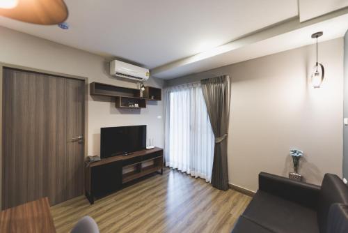 a living room with a flat screen tv and a window at W2 RESIDENCE in Ban Zong Katiam
