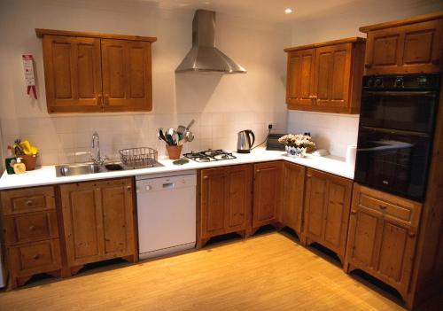 a kitchen with wooden cabinets and a stove top oven at Beaufort House in Beaufort