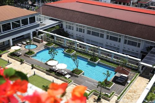 een uitzicht op een gebouw met een zwembad bij Grand Hotel Preanger in Bandung