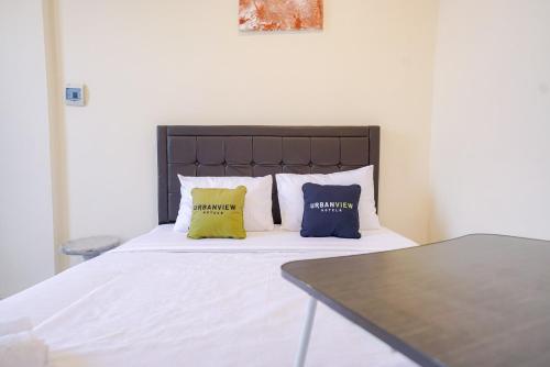 a bedroom with a bed with two pillows on it at Urbanview Hotel Gatot Subroto Lampung by RedDoorz in Geruntang