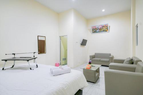 a living room with a couch and a table at Urbanview Hotel Gatot Subroto Lampung by RedDoorz in Geruntang