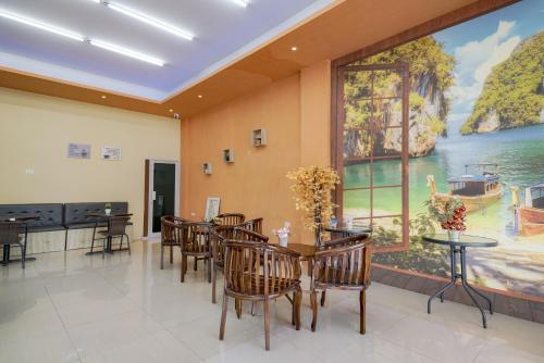 a dining room with tables and chairs and a large window at Urbanview Hotel Gatot Subroto Lampung by RedDoorz in Geruntang