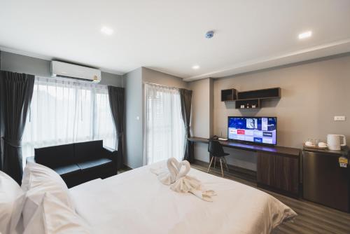 a bedroom with a white bed and a flat screen tv at W2 RESIDENCE in Ban Zong Katiam