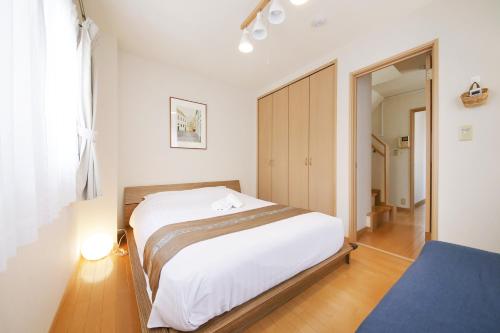 a bedroom with a large white bed and a mirror at 押上ハウス in Tokyo