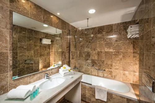 赫索尼索斯的住宿－Annabelle Beach Resort，带浴缸、水槽和镜子的浴室