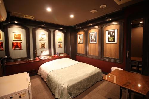 Un dormitorio con una cama y una mesa. en Hotel OLDSWING Adult Only, en Tokio