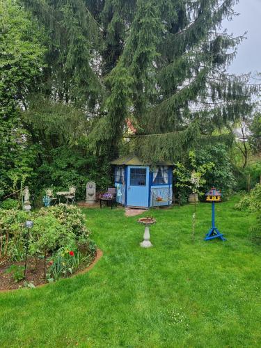 a yard with a blue shed and a tree at B&B DRESSINGS TRAUMGARTEN in Kaiserslautern
