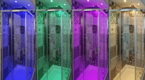 uma casa de banho com cabinas de duche em vidro roxo e verde em Prima Stella Tourist Rooms em Minturno