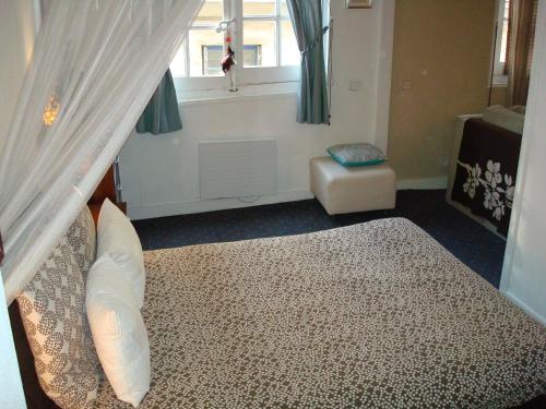 een slaapkamer met een bed, een raam en een stoel bij Beautiful Old property in Bordeaux Center in Bordeaux