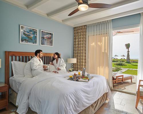 a man and woman sitting on a bed in a bedroom at Four Seasons Hotel Alexandria At San Stefano in Alexandria