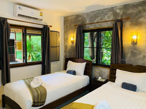 two beds in a room with two windows at Pagi Pagi villas in Ao Nang Beach