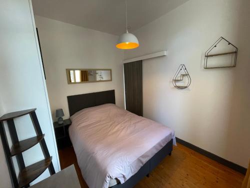 - une petite chambre avec un lit et une lampe dans l'établissement 2- Quartier historique aux pieds des falaises, au Tréport