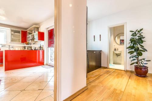 a kitchen with red cabinets and a potted plant at Modern City-Centre Penthouse with Spectacular Views / 135sqm in Zagreb