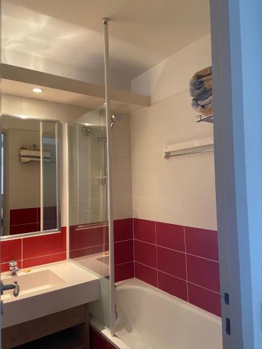 une salle de bain avec une baignoire, un lavabo et un miroir dans l'établissement Appartement charmant à La Tania, Courchevel, à Courchevel
