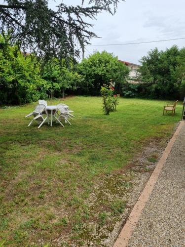 a picnic table and a bench in the grass at 2 chambres indépendantes dans Maison de maitre in Carmaux