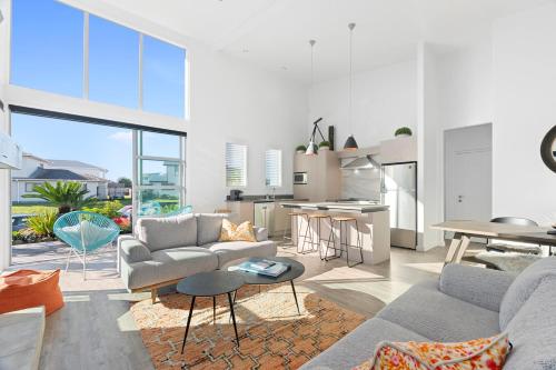 a living room with a couch and a table and a kitchen at Beachy on Bream - Ruakākā Holiday Home in Ruakaka