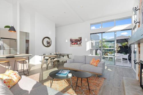 a living room with a couch and a table at Beachy on Bream - Ruakākā Holiday Home in Ruakaka