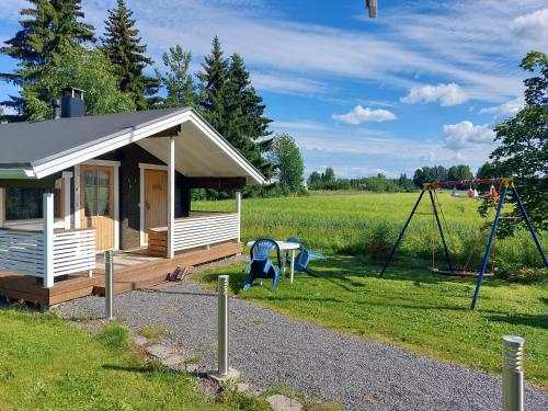 a small house with a playground and a swing at Villa Orismala in Isokyrö