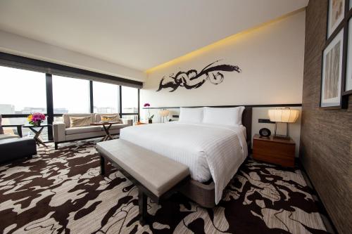 a bedroom with a large bed and a living room at City of Dreams - Nobu Hotel Manila in Manila