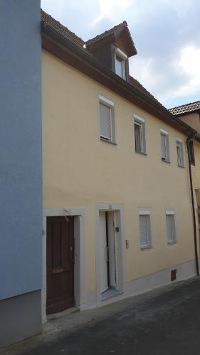 un edificio blanco con una puerta marrón en una calle en Ferienhaus Kir en Volkach