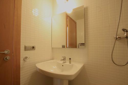 a white bathroom with a sink and a mirror at Mazi Apartments Downtown in Mataró