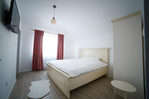 1 dormitorio con cama, ventana y mesa en Golden House Banffy en Topliţa