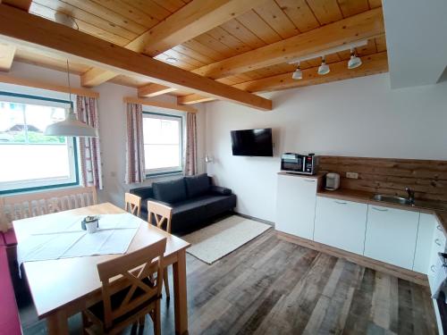 a kitchen and living room with a table and a couch at Haus Ofner am Kreischberg in Sankt Georgen ob Murau