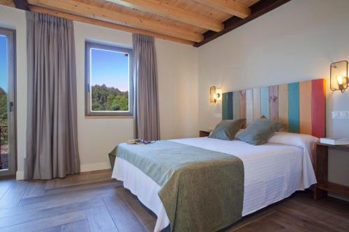 een slaapkamer met een bed en een groot raam bij Casona Canto Llano 