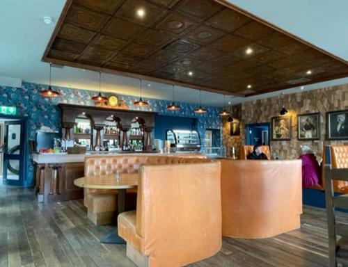 a restaurant with a bar with a table and chairs at Loch Lomond Hotel in Balloch