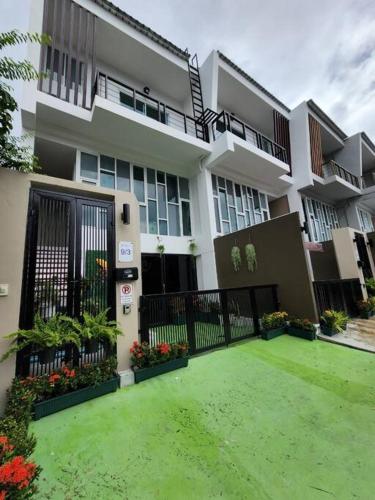 a building with a green yard in front of it at Boxsoon Nimman 3 # 4beds 4bahts in Chiang Mai