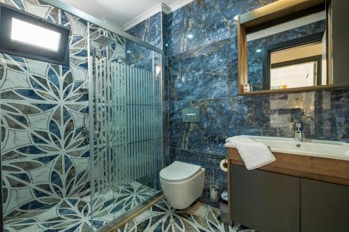 a bathroom with a toilet and a sink and a mirror at Sunrise City Residence in Fethiye