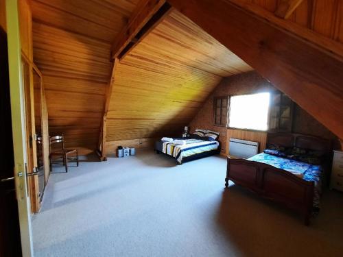 une chambre mansardée avec deux lits et une table dans l'établissement Touques maison 5mn de la mer pour 10 personnes, à Touques