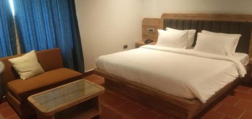 a bedroom with a large bed and a chair at Riviera Beach Resort in Chīrāla