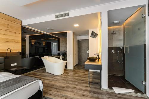 um quarto com uma banheira e uma casa de banho em B THE HOTEL em Sfântu-Gheorghe