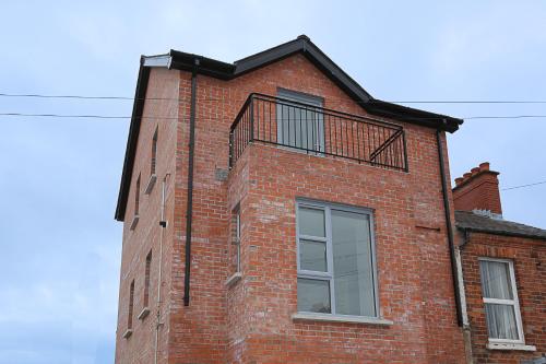 ein Backsteingebäude mit einem Balkon an der Seite in der Unterkunft No1 Luxury Service Apartments in Belfast